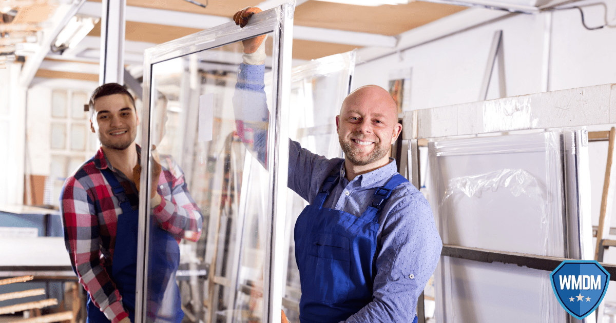 window replacement Two men holding a framed glass window ready to install.