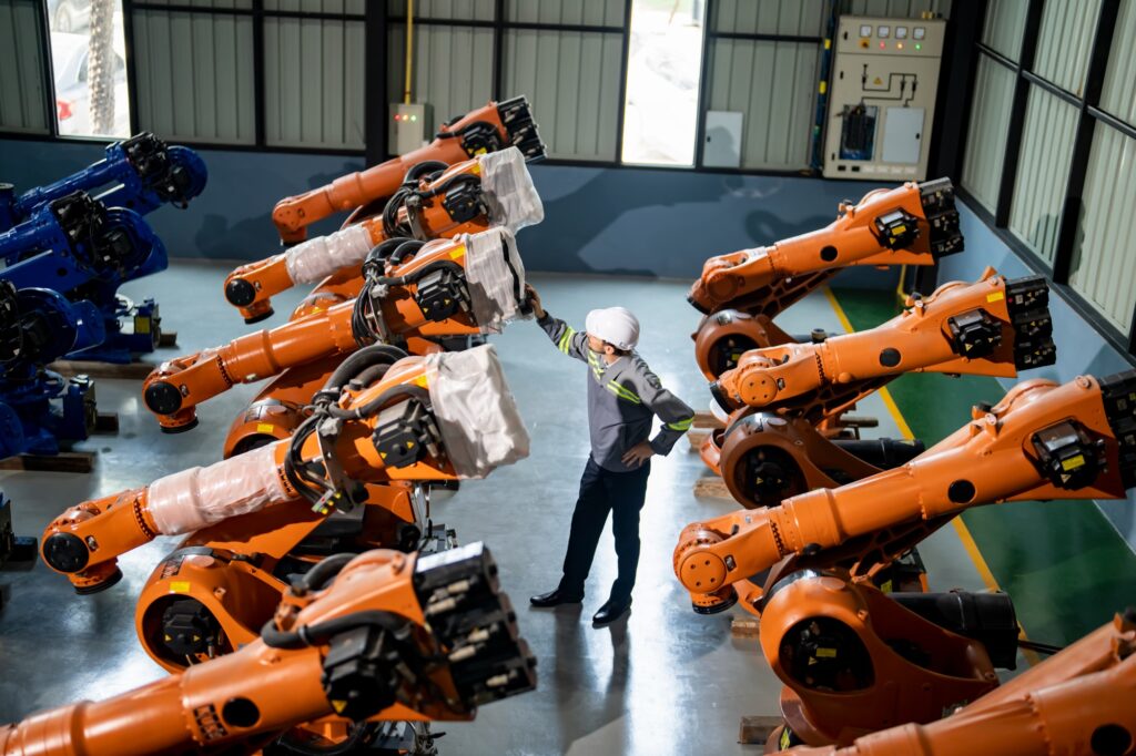 Engineer inspecting automatic AI robot arm and machines in factory. Engineer inspecting automatic AI